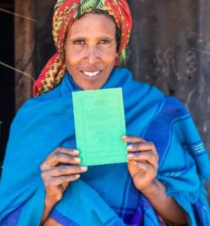 Ethiopian woman displaying land certificate